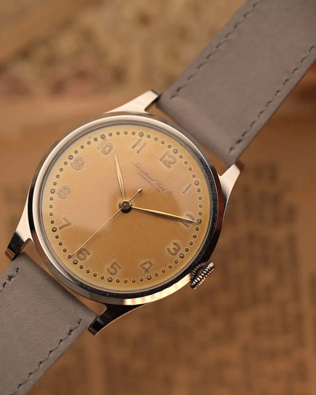 IWC Cal. 89 crème brûlée dial at a front three-quarter angle on grey suede strap
